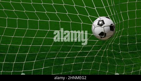 Gros plan de la balle de football noir et blanc dans le filet de but sur le gazon vert du terrain de football avec lignes de marquage blanches, grand angle, bac arrière Banque D'Images