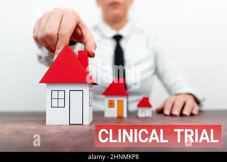 Affiche présentant un essai clinique, mot écrit sur les essais pour évaluer l'efficacité et l'innocuité des médicaments différents plans pour les maisons représentées b Banque D'Images