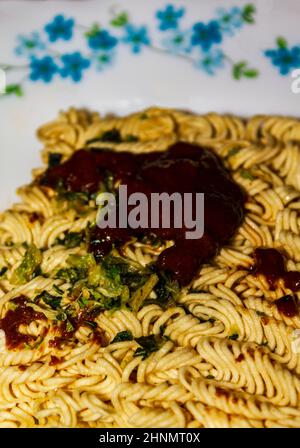 Manger malsain tard la nuit. Préparez une soupe instantanée de nouilles avec de la sauce. Banque D'Images