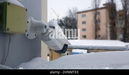 Grande caméra de surveillance blanche au-dessus d'une fenêtre sur la toile de fond d'un bâtiment public. Gros plan. Caméra CCTV installée sur la fenêtre extérieure de la maison. Banque D'Images