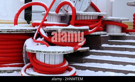 Grandes bobines de tuyau annelé flexible rouge utilisées pour protéger les câbles dans les installations électriques. Beaucoup de tuyau en plastique polyéthylène coloré utilisé dans la construction pour les systèmes de plomberie. Banque D'Images