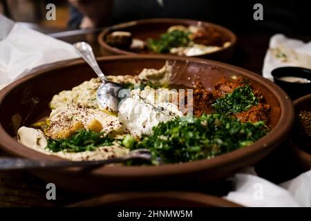 Assortiment de plats du Moyen-Orient incluant houmous, baba ghanoush, tabouleh, salade. Hors-d'œuvre orientaux sur des assiettes rouillées Banque D'Images