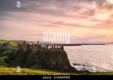 Ciel spectaculaire au-dessus des ruines du château de Dunluce perché au bord de la falaise, Bushmills Irlande du Nord lieu de tournage de la populaire série télévisée Game of Thrones Banque D'Images