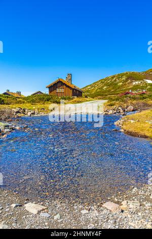 Rivière et chalets huts lac Vavatn panorama paysage Hemsedal Norvège. Banque D'Images