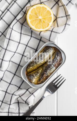 Sardines en conserve.Poisson de mer en boîte sur table blanche en bois.Vue de dessus. Banque D'Images