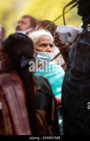 Photo d'une femme indienne âgée se tient dans la foule de Thaipusam portant le masque de protection Covid-19 Banque D'Images