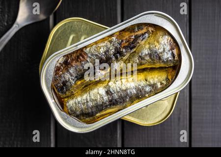 Sardines en conserve.Poisson de mer en boîte sur table noire.Vue de dessus. Banque D'Images