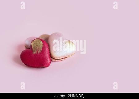 Macarons en forme de cœur sur fond rose pastel. Concept pour la Saint-Valentin. Placer pour le texte. Banque D'Images