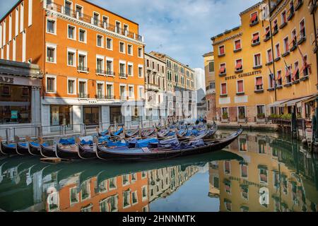 Les gondoles se gardent dans le canal près de San Marco avec le reflet de la boutique Zara et de l'hôtel Cavalletto Banque D'Images