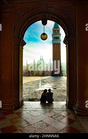 Couple regarde le lever du soleil sur la place Saint-Marc avec vue sur la basilique de San Marco dans la lumière du matin Banque D'Images