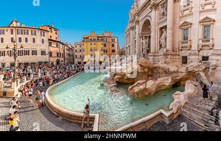 Les gens visitent la fontaine de Trevi à Rome. Jeter des pièces de monnaie dans la fontaine devrait donner de la chance au peuple. Banque D'Images