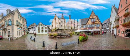 Petite route pittoresque avec maisons à colombages dans le village historique d'Eguisheim en Alsace Banque D'Images