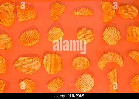 Collection de frites de pommes de terre frites sur fond orange. Goût de piment et de pomme de terre. Nourriture à la poubelle. Banque D'Images