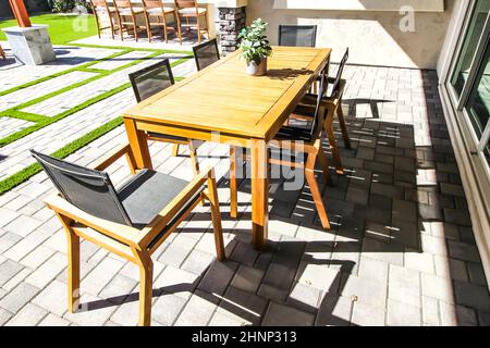 Table en bois avec six fauteuils sur le patio des finisseurs arrière Banque D'Images