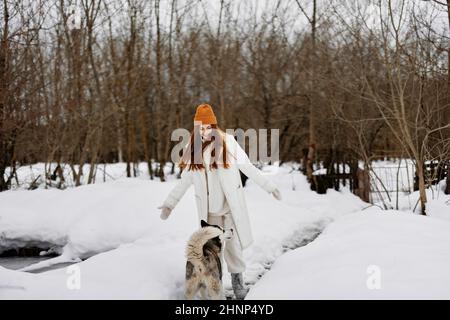 Femme gaie dans la neige jouant avec un chien sympa amitié mode de vie Banque D'Images