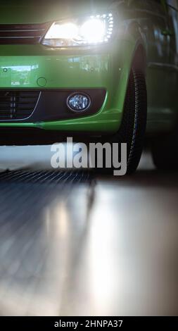 Voiture dans un garage pour l'entretien, l'huile, le changement de pneu (photo à coloration DOF peu profonde) Banque D'Images