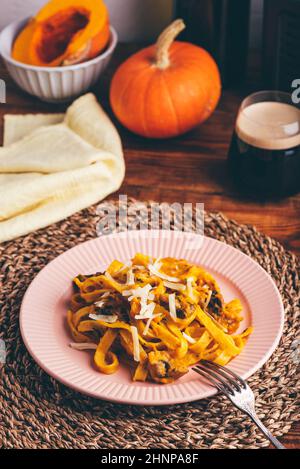 Portion de pâtes à la citrouille avec de la crème à l'écume et des champignons Banque D'Images