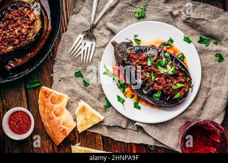 Aubergine cuite farcie de bœuf haché, de tomates et d'épices sur une assiette blanche. Plat traditionnel Karniyarik de cuisine turque. Vue de dessus Banque D'Images