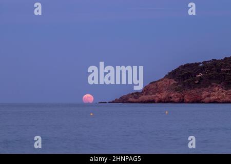 lune rose s'élevant sur la mer méditerranée depuis la plage de pals sur la costa brava Banque D'Images