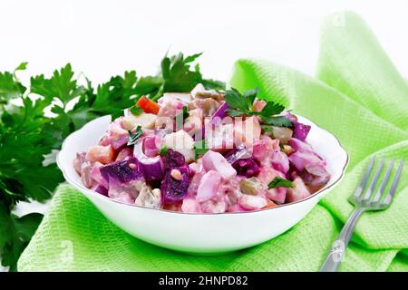 Salade de rosoli finlandais de hareng, betteraves, pommes de terre, concombres marinés ou marinés, carottes, oignons et œufs, vêtus de mayonnaise dans un bol en bois Banque D'Images