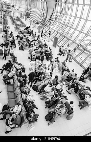 Les gens attendent sur les bancs pour le départ de leur vol à l'aéroport international de Suvarnabhumi Banque D'Images