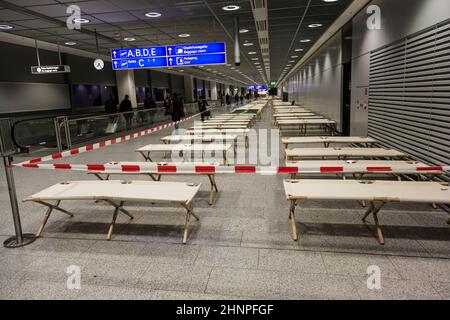 les lits de camp vides sont debout rangée par rangée dans le terminal de l'aéroport Banque D'Images