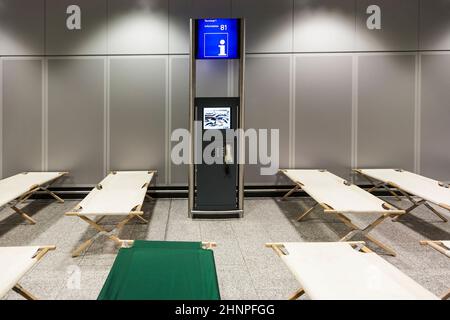 les lits de camp vides sont debout rangée par rangée dans le terminal de l'aéroport Banque D'Images