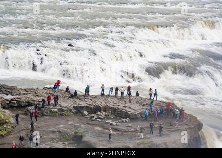 Les gens regardent les cascades de Hraunfossar, situées près de Husafell et Reykholt dans l'ouest de l'Islande Banque D'Images