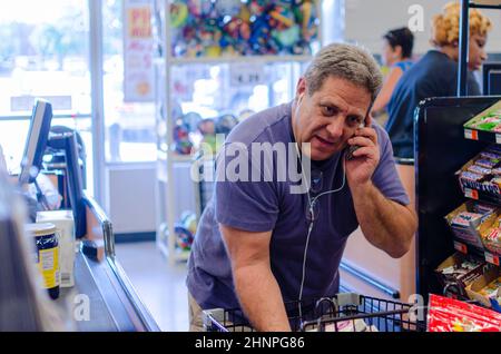 New Orleans, LA, États-Unis - 3 JUIN 2013 : l'homme a absorbé dans la conversation de téléphone cellulaire lors de son départ à l'épicerie Banque D'Images