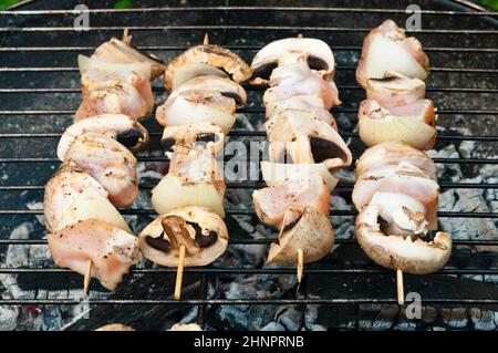 Les brochettes de poulet avec champignons torréfaction sur un vieux barbecue Banque D'Images