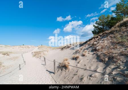 Ciel bleu avec quelques nuages sur sentier à travers les dunes de sable Banque D'Images