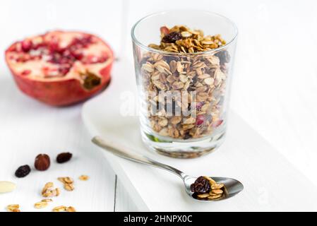 Muesli muesli frais dans un verre d'amandes, les raisins secs et la grenade. Petit déjeuner sain. Banque D'Images