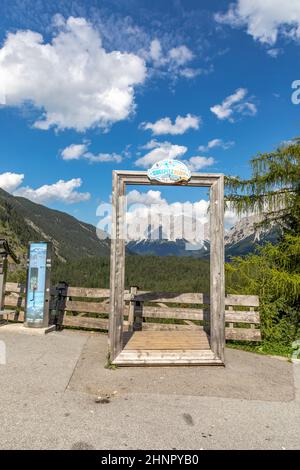 Vue célèbre à travers un cadre en bois à la belle montagne de la zone de repos 'Zugspitzblick' sur la route alpine de Fernpass à la montagne de Zugspitze , Alpes, Autriche, Europe. Banque D'Images