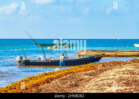 Bateaux dans l'algue rouge Sargazo plage Playa del Carmen Mexique. Banque D'Images