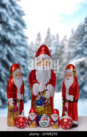 Carte de vœux de Noël. Gros plan de divers joyeux Noël au chocolat enveloppé sur un paysage d'hiver flou et festif. Bonbons cadeaux de Noël et du nouvel an. Macro. Banque D'Images