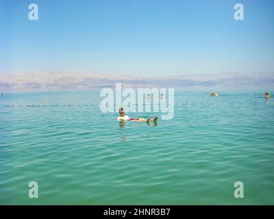 Les gens flottant sur l'eau dans la mer Morte Israël Banque D'Images