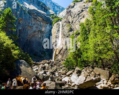 Les touristes rafraîchissent leurs jambes dans le lac de la chute d'eau inférieure de Yosemite Banque D'Images