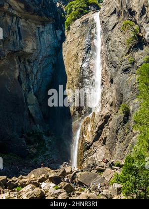 Les touristes rafraîchissent leurs jambes dans le lac de la chute d'eau inférieure de Yosemite Banque D'Images