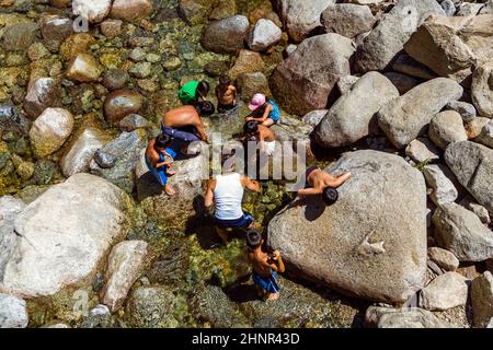 Les touristes rafraîchissent leurs jambes dans le lac de la chute d'eau inférieure de Yosemite Banque D'Images