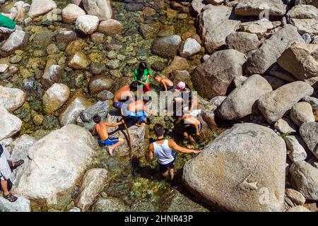 Les touristes rafraîchissent leurs jambes dans le lac de la chute d'eau inférieure de Yosemite Banque D'Images