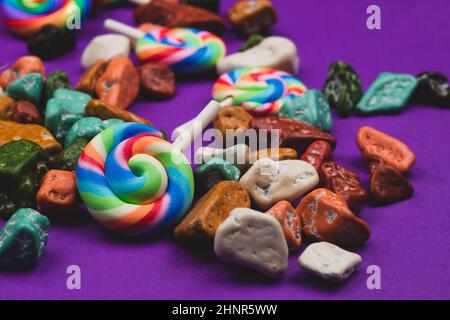 Sucettes et bonbons. Bonbons sous forme de pierres colorées. Fond coloré avec bonbons colorés. Décoration festive Banque D'Images
