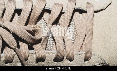 Laçage sur la chaussure beige. Lacets sur la sneaker près du haut Banque D'Images