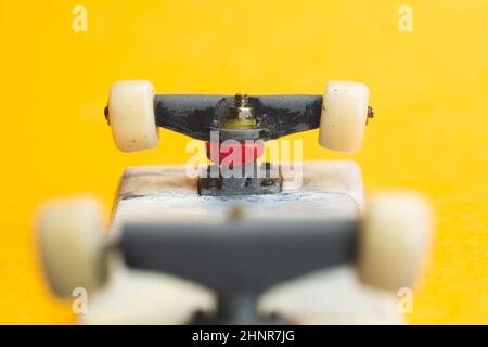 Petit skateboard sur fond jaune. Petit skate pour les doigts. Petit skate pour les doigts Banque D'Images