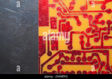 Circuit imprimé fait main avec pistes soudées rouges. Arrière-plan industriel. Textolite avec soudure Banque D'Images