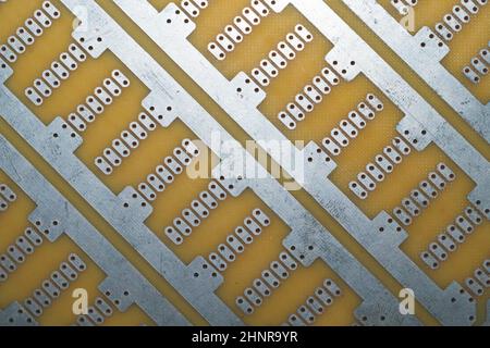 Carte de circuit imprimé sans éléments. Surface en textolite. Modèle pour souder le circuit. Fond perforé Banque D'Images