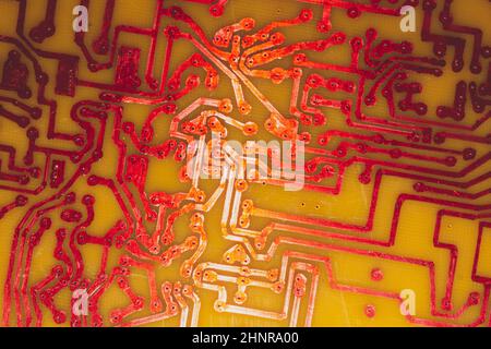 Circuit imprimé fait main avec pistes soudées rouges. Arrière-plan industriel. Textolite avec soudure Banque D'Images