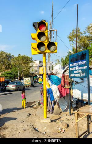 Scène de rue avec des gens et des feux de circulation dans le quartier pauvre de New Delhi Banque D'Images