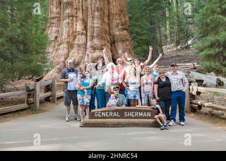 Les gens ont un selfie devant l'arbre du général sherman dans le parc national Sequoia Banque D'Images