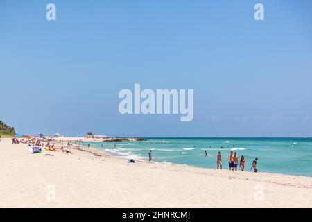 Les touristes se baignent dans le soleil, nagent et jouent sur South Beach à Miami Beach, en Floride Banque D'Images