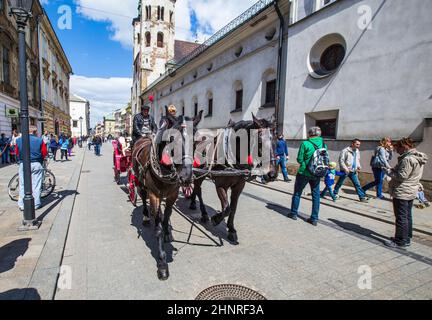 Les gens apprécient la calèche tirée par des chevaux sur la place du marché Banque D'Images